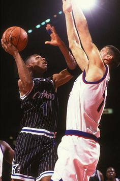 two basketball players trying to block the ball