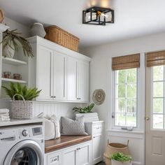 a washer and dryer in a white laundry room with lots of storage space