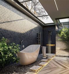 a bathtub sitting in the middle of a bathroom next to a plant and window