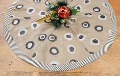 a round table with black and white polka dots on it, decorated with a red christmas ornament