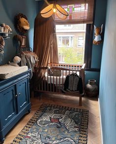 a baby's room with blue walls and furniture