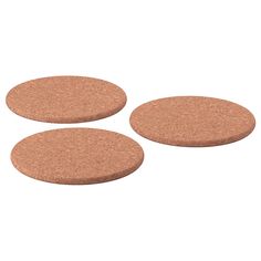 three cork coasters are shown on a white background and one has a brown surface