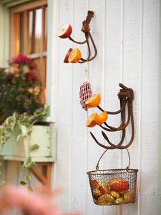 an orange slice hanging on the side of a wall next to a basket filled with fruit