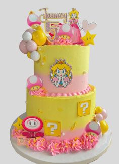 a three tiered cake with pink and yellow icing on it's side