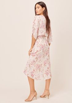 Bring on the romance in our dreamy floral print midi faux wrap dress. Featuring flirty tulip sleeves, a smocked elastic waist for definition, and feminine ruffle details. The soft watercolor brush strokes in the pink and cream floral print adds a sweet touch, while the subtle metallic details catch the light as you move. FINAL SALE Relaxed fit Elbow-length sleeve Mid-length V-neckline Hook & eye closure Model is 5'10, wearing a size S.Style: I-71882WL-QWO-LL Floral Print Dress With Surplice Neckline For Brunch, Feminine Surplice Neckline Midi Dress For Brunch, Feminine Midi Dress With Surplice Neckline For Brunch, Feminine Floral Dress With Surplice Neckline For Brunch, Feminine Midi Dress With Surplice Neckline For Daywear, Feminine Floral Dress With Surplice Neckline For Garden Party, Feminine Mid-length Floral Dress For Brunch, Feminine Flowy Midi Dress With Floral Print, Modest Midi Dress With Floral Print And Flutter Sleeves