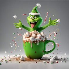 a green mug filled with marshmallows, candy canes and sprinkles