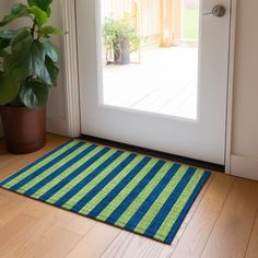 a blue and green rug sitting on top of a wooden floor next to a door