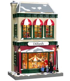 a doll house with people standing in front of it and the storefront is lit up