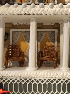 two miniature wooden chairs sitting on top of a shelf in front of a wall decoration