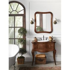 a bathroom with a sink, mirror and potted plant on the floor next to it