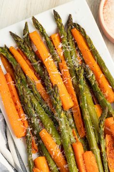 asparagus, carrots and parmesan cheese on a white platter