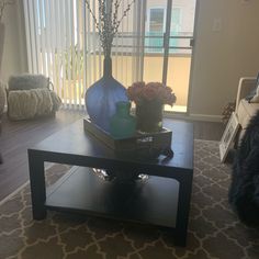 a living room with a coffee table and vases on it