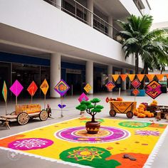 an outdoor area decorated with brightly colored carpets and colorful decorations on the ground in front of a building