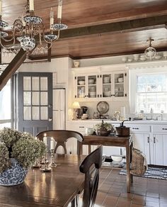 a dining room table with chairs and a chandelier hanging from it's ceiling