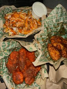 three baskets filled with different types of food next to a container of sauce and fries