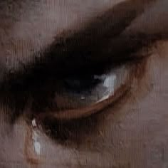 an image of the eye of a person with tears on their iris and part of his face