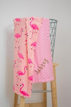 pink flamingos and polka dots are on the back of a chair with a personalized beach towel