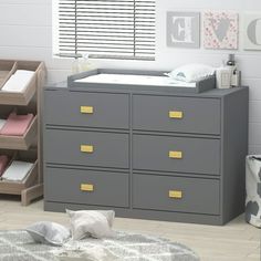 a baby's room with a dresser, changing table and crib