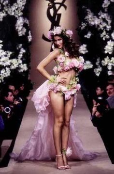 a model walks down the runway in a pink dress with flowers all over her body