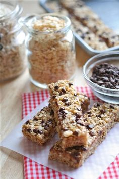 three granola bars sitting on top of a red and white checkered napkin