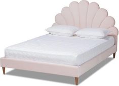 a pink bed with white pillows and an upholstered headboard on the side