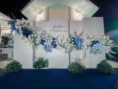 a blue and white floral arrangement on display in front of a building