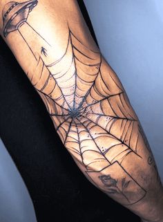 a man with a spider web tattoo on his arm