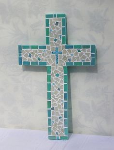 a wooden cross sitting on top of a table next to a white and blue wall