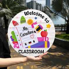 a person holding up a sign that says welcome to my caribine classroom