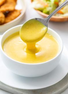 a spoon full of soup on top of a white plate