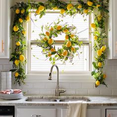 a kitchen window decorated with lemons and greenery