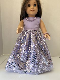 a doll wearing a purple dress with sequins