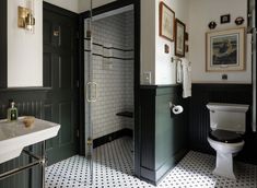 a bathroom with black and white tile flooring and green doored shower stall next to the toilet