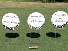 three white golf balls sitting on top of a green grass covered field next to each other