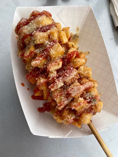 some kind of food on a white plate with a wooden utensil next to it