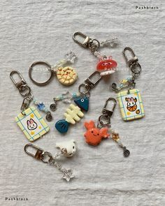 a bunch of keychains that have various items on them, all in different shapes and sizes