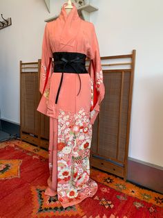 A beautiful, pink silk kimono. The  kimono is intricately patterned with peacocks, plum blossom, chrysanthemums, and lots of other flowers and patterns. There is also delicate gold embroidery and detailing. The silk itself is also woven with a pattern of flowers and traditional Japanese design. This would make a beautiful party dress, or would be a luxurious silk robe.  The condition of this kimono is good, especially for a vintage piece. There are a few marks. This Kimono is from Kyoto, Japan T Pink Kimono For Spring Wedding, Spring Wedding Pink Kimono, Traditional Pink Kimono For Spring, Pink Silk Kimono For Wedding, Pink Silk Long Sleeve Kimono, Pink Silk Wedding Kimono, Traditional Spring Wedding Kimono, Pink Silk Kimono For Spring, Pink Kimono With Kimono Sleeves For Tea Ceremony