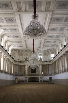 an ornate building with chandeliers and pillars in the ceiling, along with columns on either side