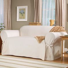 a living room with a couch covered in a white cover