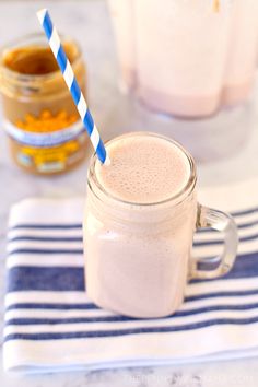 a smoothie in a mason jar with two blue and white striped straws