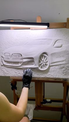 a person is painting a car on a canvas