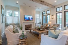 a living room filled with furniture and a flat screen tv mounted on the wall above a fireplace