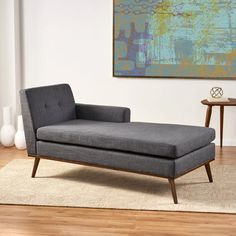 a gray chaise lounger sitting on top of a rug in a living room