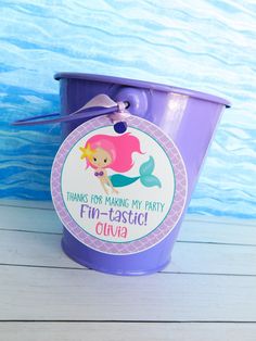 a purple bucket with a little mermaid on it and a tag that says, thanks for making my party fun - casti luna