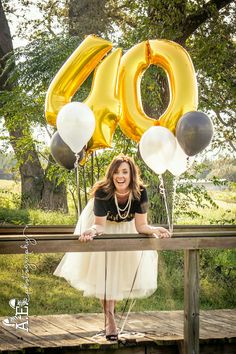 a woman standing on a bridge with balloons in front of her and the number 50