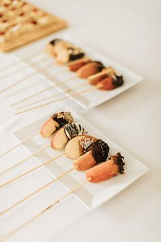 small appetizers are lined up on plates with toothpicks sticking out of them