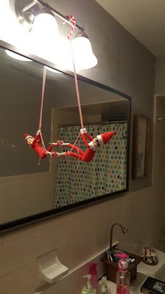 a bathroom with a sink, mirror and light fixture hanging from it's ceiling