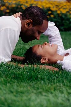 a man and woman laying in the grass