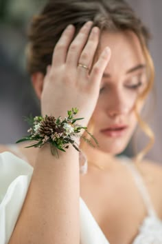 a woman in white dress holding her hand to her head