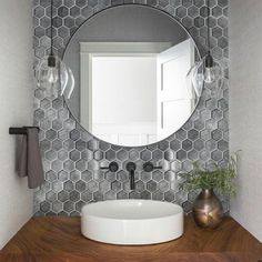 a bathroom sink with a round mirror above it